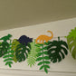 Cappa creations hand made paper banner, handmade designs, Jurassic birthday party theme, dinosaur birthday, tropical dino banner, three-rex birthday celebration, tropical Jurassic banner with monstera and palm leaves, colorful and bold dinosaurs, gold glitter dinos, tyrannosaurs rex, triceratops, long neck, brontosaurus, stegosaurus