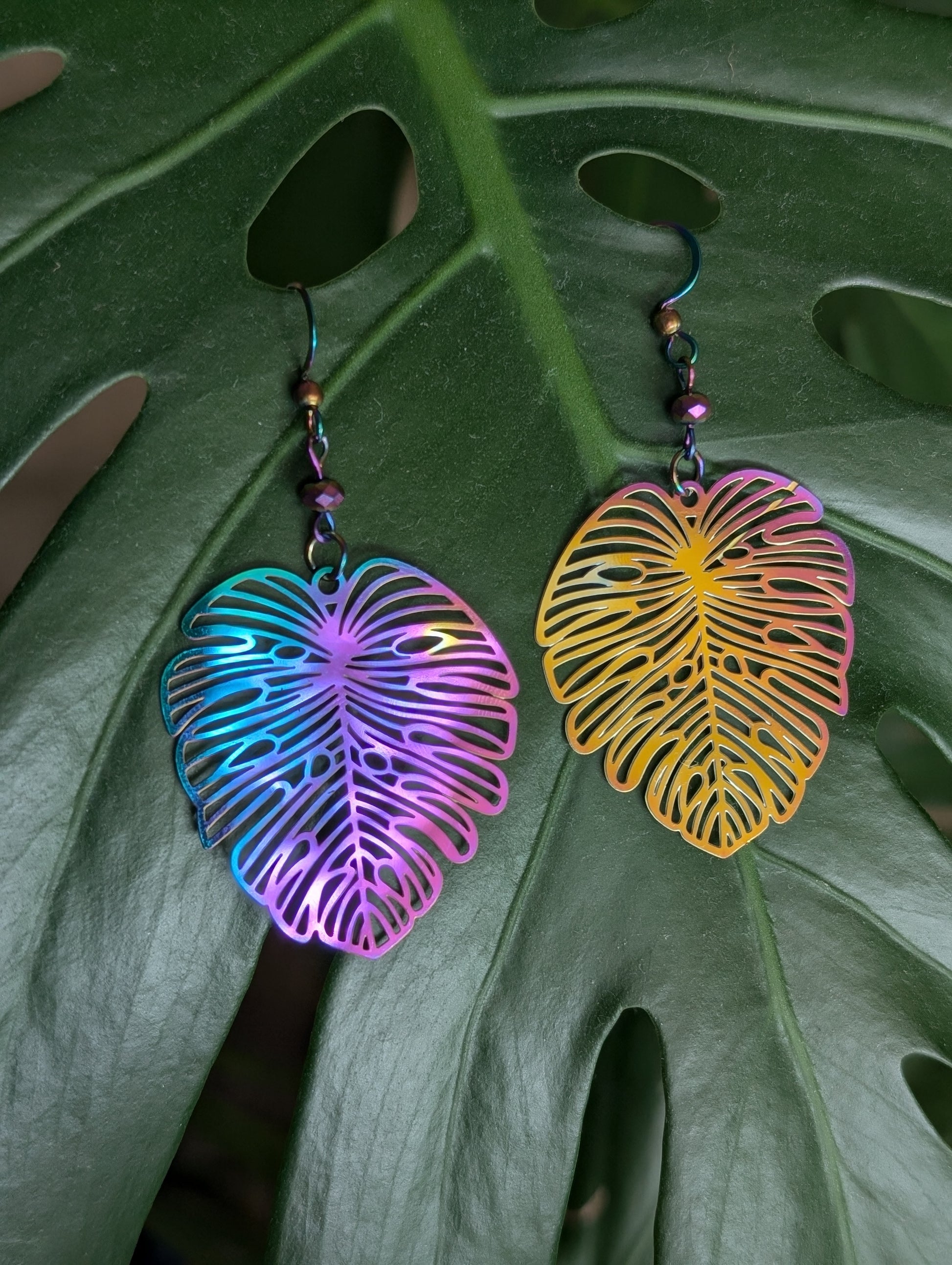 Lightweight rainbow Monstera dangling earrings, rainbow anodized stainless steel. Handcrafted by Cappa Creations, made of stainless steel, making them the highest quality, waterproof, tarnish proof, hypoallergenic, and nickel free! 

Perfect to wear on a beautiful summer day or  the sweetest gift for any plant lover! 