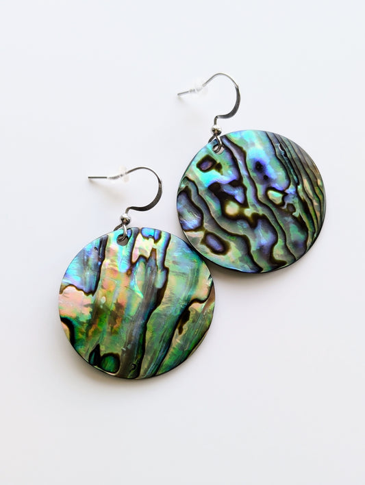 Close-up of 18k gold plated abalone shell earrings with white gold hooks, showcasing their iridescent 30 mm shells.