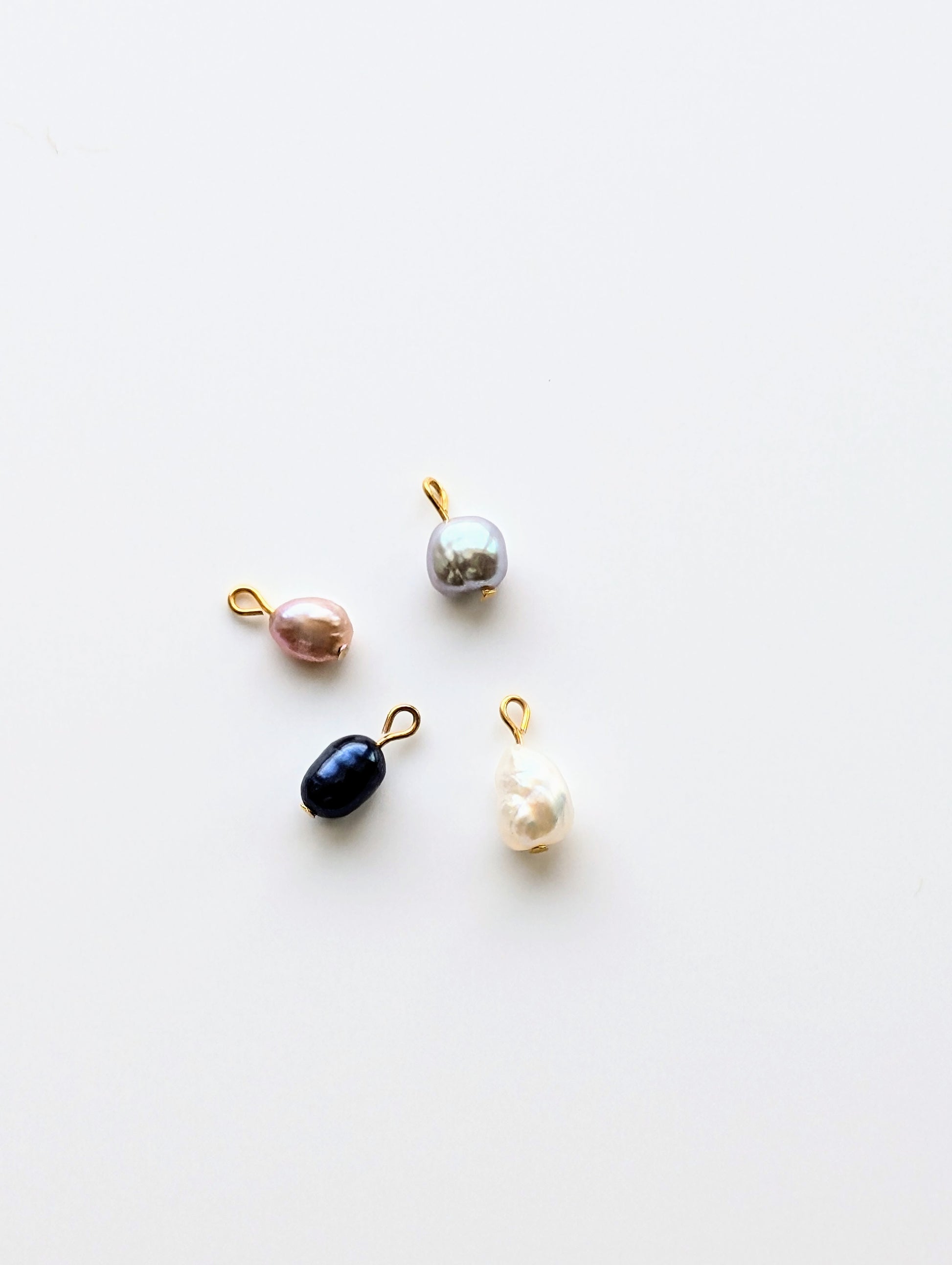 18K Gold Plated fresh water pearl charms with lobster claw clasp for adjustable placement. available in 4 pearl variations; white, blush, grey, and black.