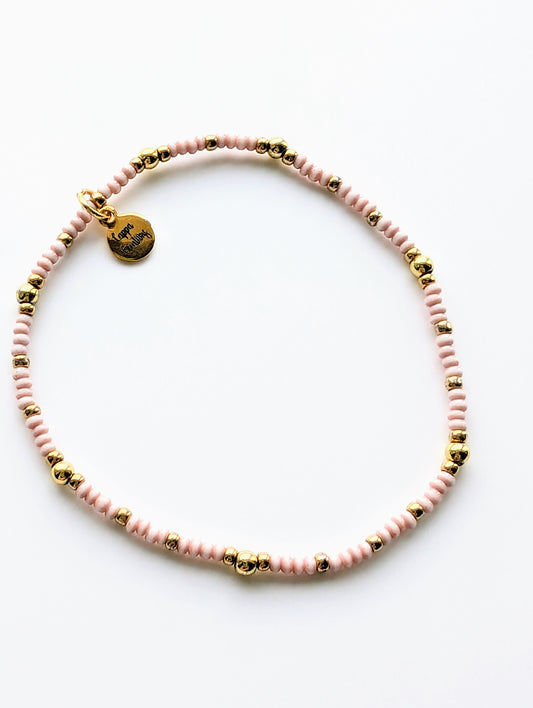 Micro Goldy Bracelet featuring dainty 18k gold-plated beads, displayed on a soft background.