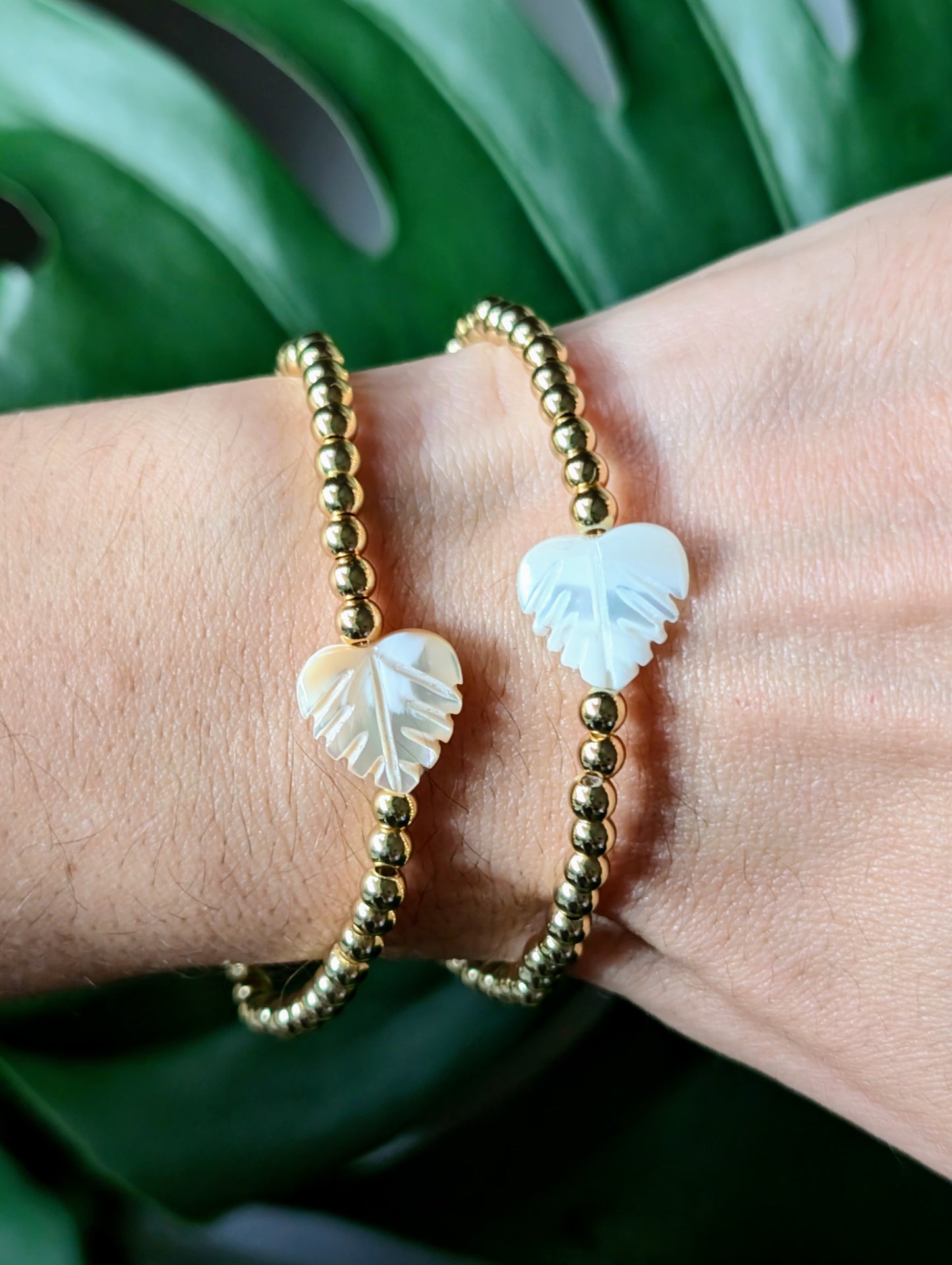 Monstera Leaf Gold Bracelet with 18k gold-filled beads and cream & white mother-of-pearl leaves, styled on a clean background.